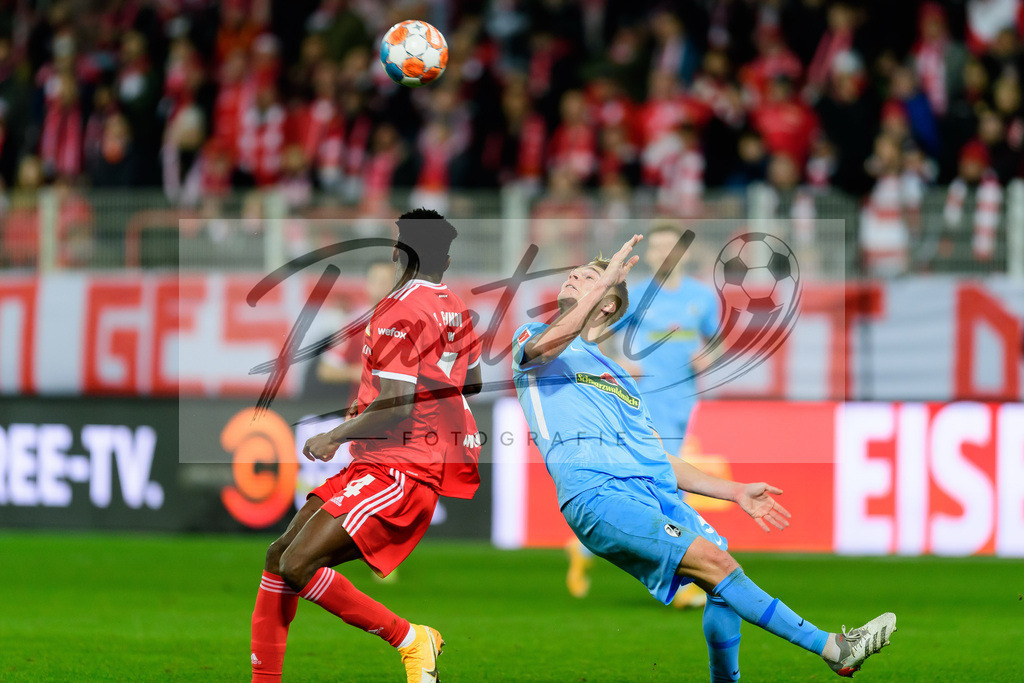 FCUFRE20211215_029 | Fussball, Herren: Taiwo Awoniyi (1. FC Union Berlin) und Philipp Lienhart (SC Freiburg) im Zweikampf bei dem Spiel der 1. Bundesliga zwischen 1. FC Union Berlin und SC Freiburg im Stadion An der Alten Foersterei am 15.12.2021 in Berlin, Deutschland.DFB / DFL REGULATIONS PROHIBIT ANY USE OF PHOTOGRAPHS AS IMAGE SEQUENCES AND/OR QUASI-VIDEO. - Realisiert mit Pictrs.com