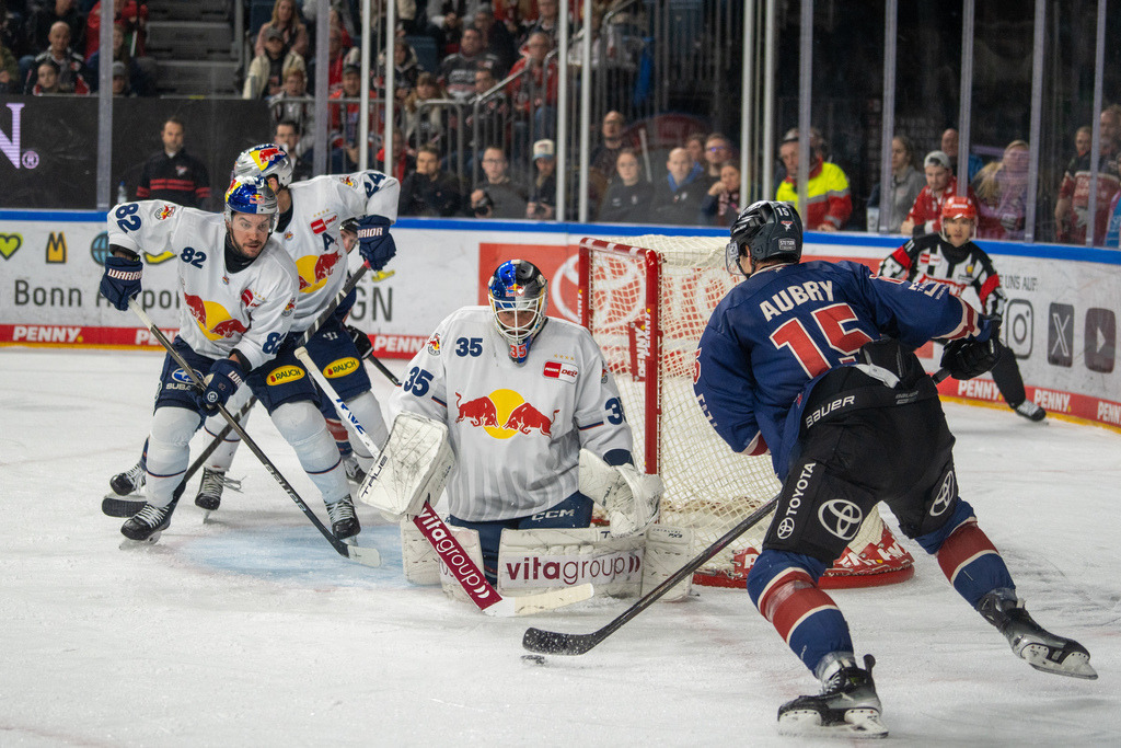 DEL, Deutsche Eishockey Liga Saison 2024/25, 33. Spieltag: Kölner Haie gegen Red Bulls München | 11.10.2024, DEL, Deutsche Eishockey Liga Saison 2024/25, 33. Spieltag: Kölner Haie gegen Red Bulls MünchenBild: Louis Marc Aubry (15, Köln), Mathias Niederberger (35, München), Christopher DeSousa (82, München) - Realisiert mit Pictrs.com