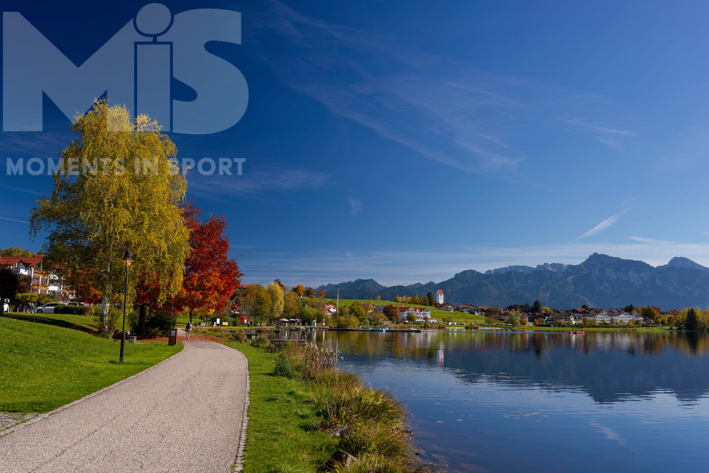 2.Liga-1860-HEIM.jpg | 17.10.2022, Herbst am Hopfensee im Allgäu (Bayern) bei Füssen. Bei sommerlichen Temperaturen geniessen viele Ausflügler die herbstliche Landschaft am See. Hier die Promenade in Hopfen am See. - Realisiert mit Pictrs.com