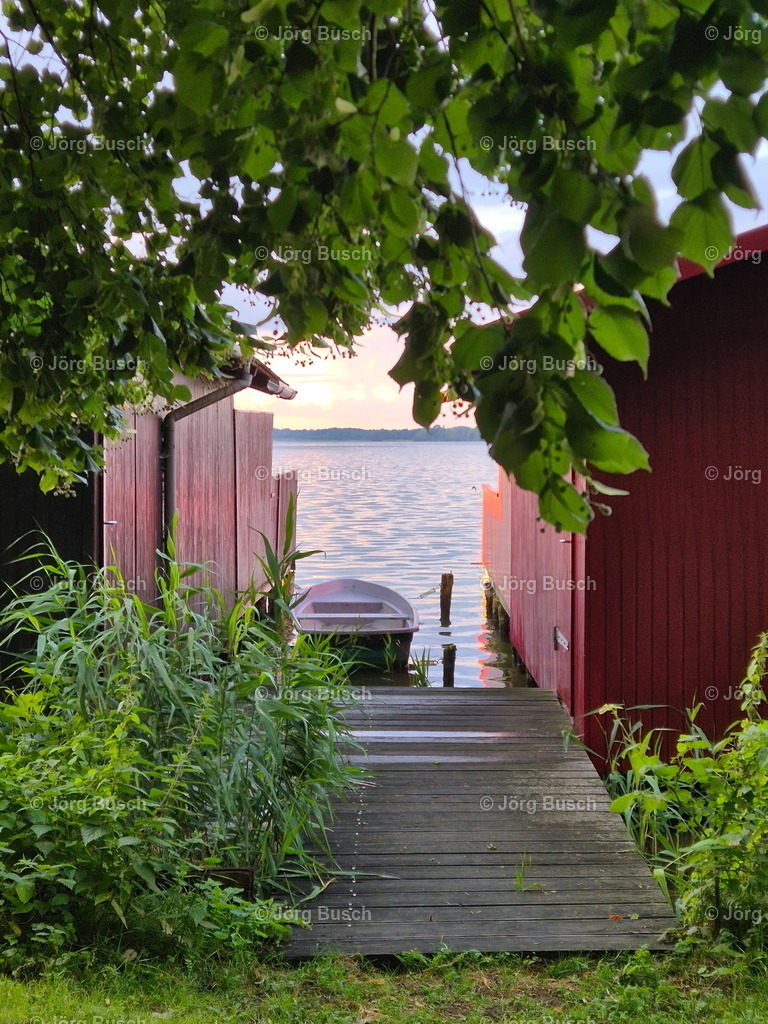 Boot zw. Bootshäusern am See mit Baum | Dieser Shop bietet Fotos und Videos aus den Bereichen Fallschirmspringen, Landschaft und Luftbild - Realizzato con Pictrs.com