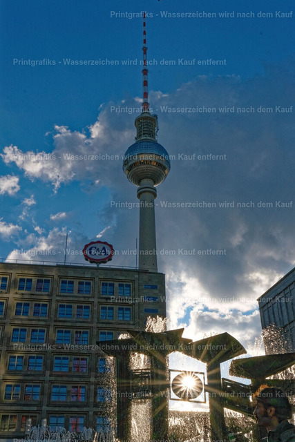 Berliner Fernsehturm im Gegenlicht | Urbane Aufnahme des Berliner Fernsehturms mit Brunnen, Sonnenstern und dramatischem Himmel. Die starke Gegenlichtstimmung verbindet moderne Stadtarchitektur mit einem lebendigen, klaren Berlin-Moment. - Realisiert mit Pictrs.com