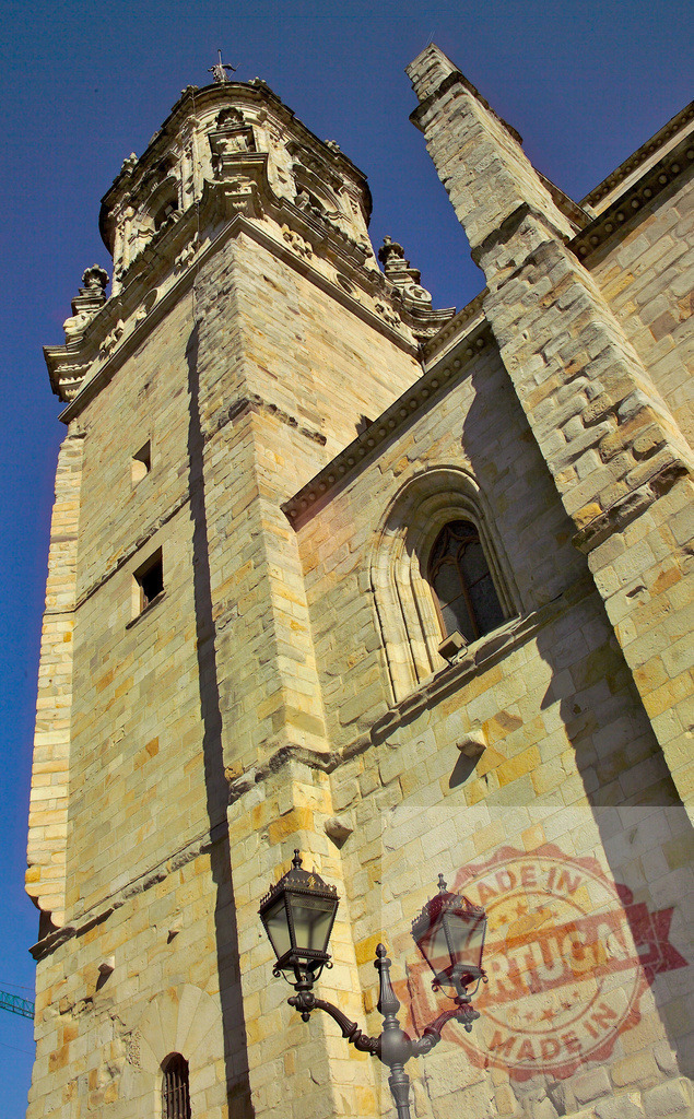 Santander Cathedral tower and flying buttress against blue sky. Spain - Bilbao | Santander Cathedral showing gothic architecture details and an old street lamp at sunny daytime - Realisiert mit Pictrs.com