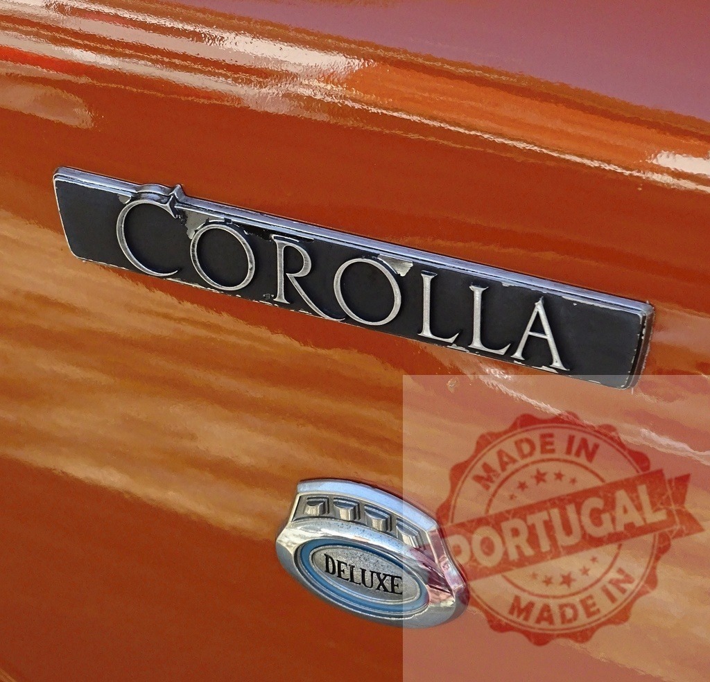 Toyota Corolla Deluxe vintage car emblem on orange classic vehicle | Toyota Corolla Deluxe badge on a classic orange automobile showing retro design - Realized with Pictrs.com