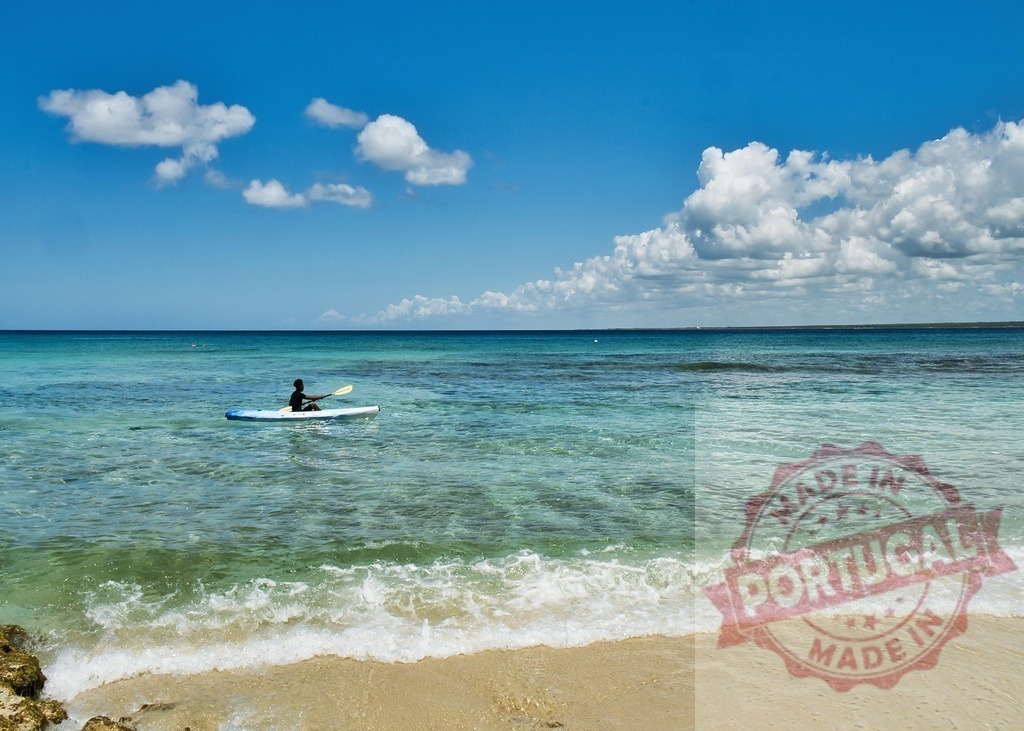 Person kayaking in Caribbean turquoise ocean water | Person paddling a kayak on clear blue tropical water near a sandy beach - Realisiert mit Pictrs.com