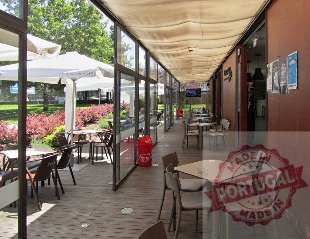 Empty outdoor cafe terrace preparing for guests | Empty outdoor cafe terrace with tables, chairs, and park view on a sunny day - Realisiert mit Pictrs.com