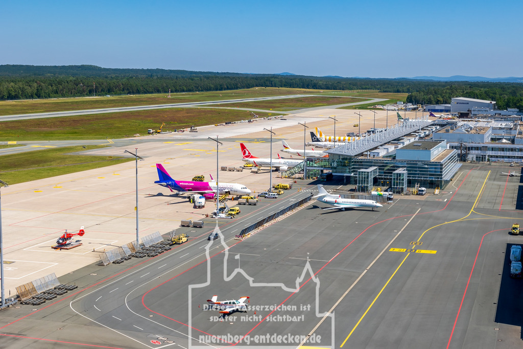 Nürnberger Flughafen | Das Terminalgebäude und Vorfeld des Albrecht-Dürer-Flughafens Nürnberg mit Flugzeugen verschiedener Fluggesellschaften. In Nürnberg findet ein gemischter kommerzieller Flugbetrieb sowie Privat- und Geschäftsflugverkehr statt. - Realisiert mit Pictrs.com