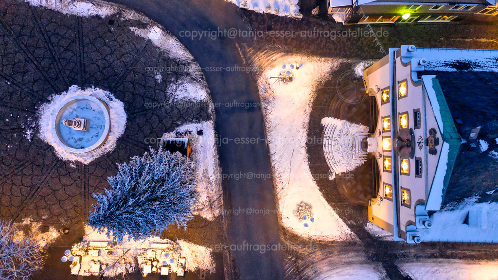 Verschneiter Briloner Marktplatz mit Rathaus und Brunnen am Abend aus der Vogelperspektive | Luftbild zeigt den Briloner Marktplatz an einem Winterabend. Stimmungsvolles winterliches Bild des beleuchteten Stadtzentrums im Schnee mit Rathaus und Petrusbrunnen.