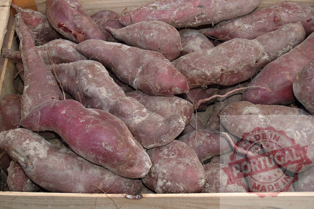 Purple sweet potatoes piling in a wooden crate | Purple sweet potatoes, freshly harvested with dirt, piled in a wooden crate, ready for market - Realisiert mit Pictrs.com