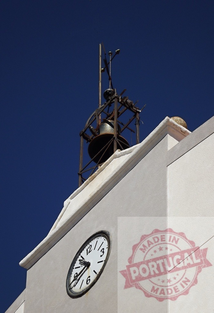 Clock tower bell and clock face against blue sky. Spain - Extremadura | Bell tower with an antique clock face visible on building, symbolizing time passing - Realized with Pictrs.com