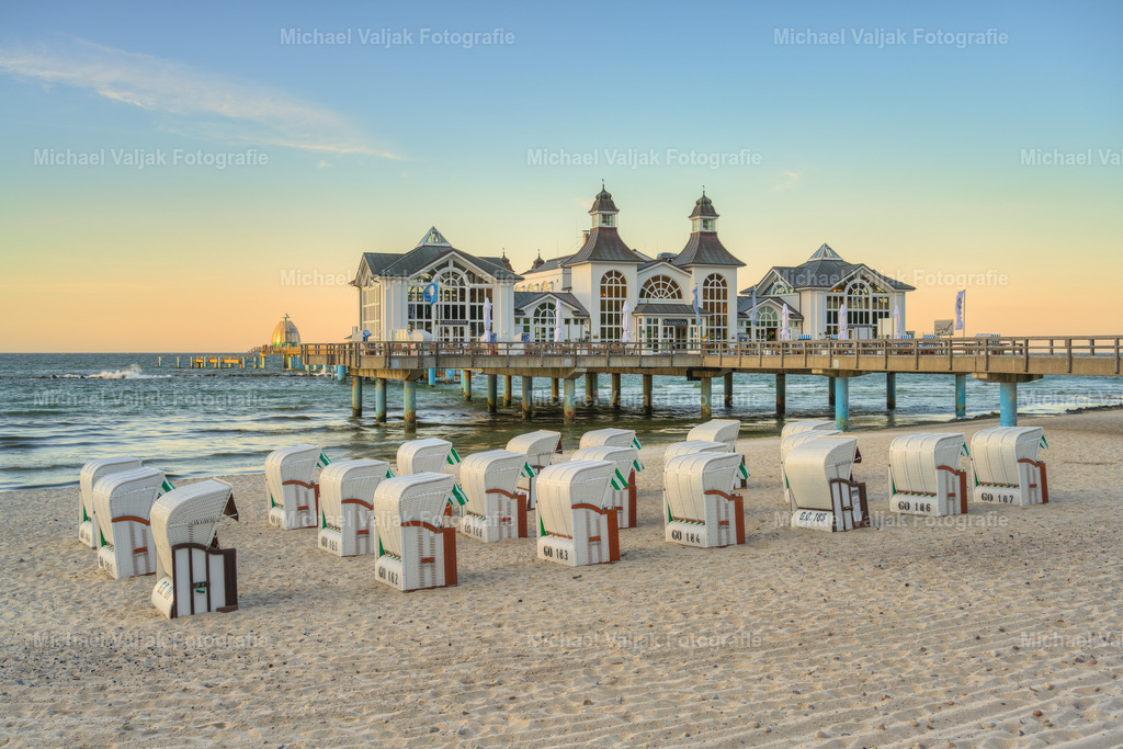 Seebrücke Sellin auf Rügen | Die Seebrücke Sellin ist eine der bekanntesten Attraktionen auf der Insel Rügen. Sie wurde ursprünglich im Jahr 1906 erbaut und ist heute ein beliebtes Fotomotiv. Besonders schön ist es, die Seebrücke bei Sonnenaufgang zu besuchen, wenn die ersten Sonnenstrahlen das Meer und die historischen Gebäude in ein warmes Licht tauchen. - Realisiert mit Pictrs.com