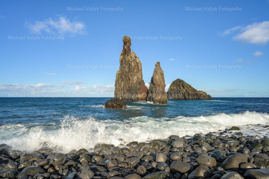 Praia da Ribeira da Janela | Der Praia da Ribeira da Janela an der Nordküste Madeiras ist ein einzigartiger Ort, der vor allem für seine spektakulären Felsformationen bekannt ist. Der Strand liegt in der Nähe des kleinen Dorfes Ribeira da Janela und ist einer der beeindruckendsten Naturstrände der Insel. Umgeben von steilen Klippen und geprägt von schwarzem Vulkansand und Kieselsteinen, bietet dieser Ort eine unvergleichliche Kulisse für Naturliebhaber.Das Wahrzeichen des Strandes sind die markanten Felsnadeln, die aus dem Atlantik ragen. Diese bizarren Felsformationen, die über Jahrtausende hinweg durch Wind und Wellen geformt wurden, verleihen dem Praia da Ribeira da Janela eine mystische Atmosphäre. - Realisiert mit Pictrs.com