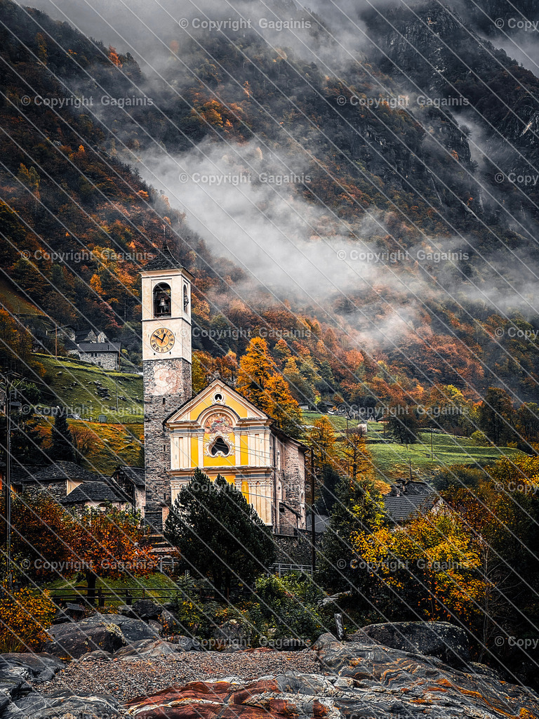 Kirche Herbstlandschaft Schweiz, Tessin Dorf  | Goldene Blätter, malerische Gassen und sanfter Herbstnebel – diese Fotografie bringt die magische Atmosphäre des Tessiner Herbstes in dein Zuhause. Perfekt für gemütliche Wohnräume oder als Geschenk für Naturliebhaber.