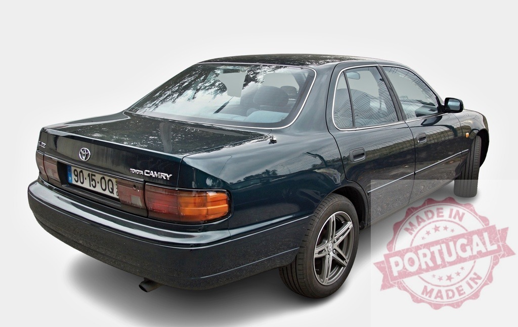Dark green Toyota Camry sedan rear view representing 90s vintage car | Dark green Toyota Camry sedan, a vintage car from the 1990s, isolated on white background - Realized with Pictrs.com