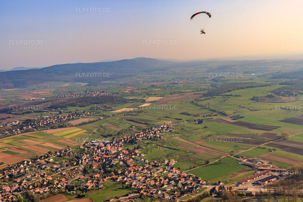 Luftbild: Dorfansicht aus Südwesten mit Paragleiter in Gunstett im Bundesland Bas-Rhin in Frankreich. – Foto: IMG_63760.jpg vom 30.03.2014 durch Werner Riehm/FLY-FOTO.de – Auflösung des Originals: 4752 x 3168 px