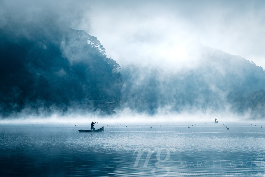 the catch of a fisherman in the mist | boat with fisherman, who just made a catch on Lake Shōji in morning mist - Realisiert mit Pictrs.com