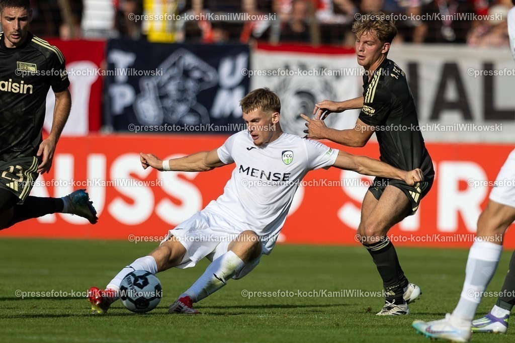 xkwix15082502106 | 15.08.2025, xkwix, Fußball, DFB-Pokal 1. Runde, FC Gütersloh - 1. FC Union Berlin, Ohlendorf Stadion im Heidewald: Luis Frieling (FC Gütersloh #21) im Zweikampf gegen András Schäfer (1.FC Union Berlin #13) und Andrej Ilić (1.FC Union Berlin #23)