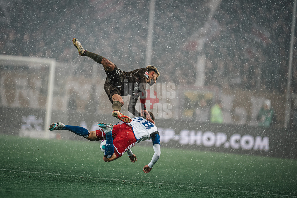 Fußball | Männer | Saison 2023/2024 | 2. Fußball-Bundesliga | 15. Spieltag | FC St. Pauli vs. Hamburger SV | 01.12.2023 | Harter Zweikampf zwischen Elias Saad (#26, oben, FC St. Pauli) und Miro Muheim (#28, unten, HSV) beide in der Luft im Schnee