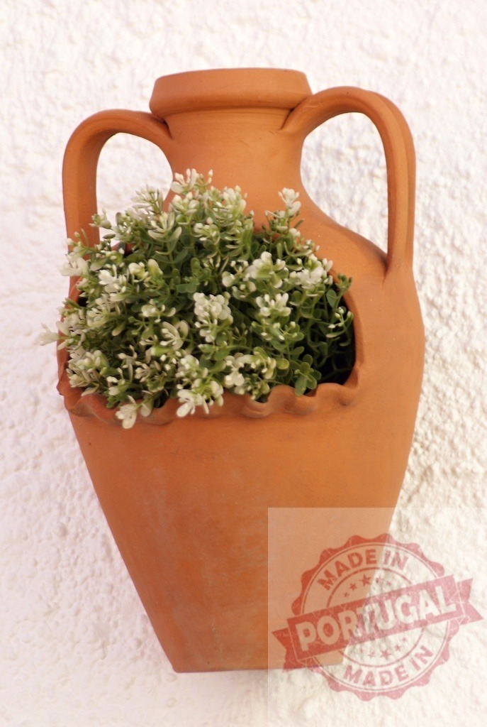 Terracotta amphora wall planter holding white flowers | Terracotta amphora planter with green plants and small white flowers mounted on a white wall - Realisiert mit Pictrs.com