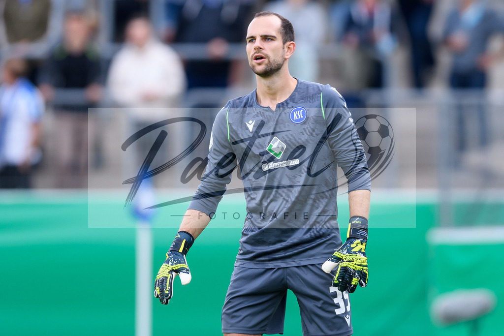 LOTKSC20210809_080 | Fussball, Herren: Torwart Marius Gersbeck (Karlsruher SC) schaut beim Spiel der 1. Runde im DFB-Pokal zwischen SF Lotte und Karlsruher SC im Stadion am Lotter Kreuz am 09.08.2021 in Lotte, Deutschland.DFB / DFL REGULATIONS PROHIBIT ANY USE OF PHOTOGRAPHS AS IMAGE SEQUENCES AND/OR QUASI-VIDEO. - Realisiert mit Pictrs.com