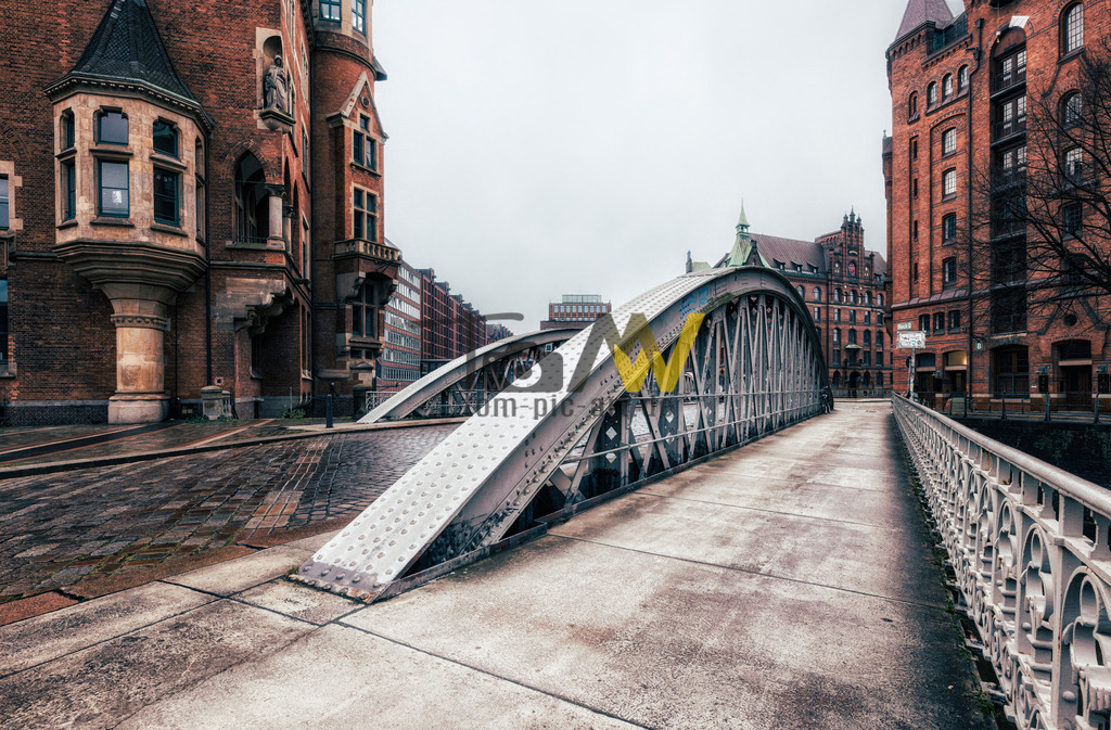 UNESCO-Weltkulturerbe Hamburger Speicherstadt, Brücke, Backstein | Das Bild zeigt die Neuerwegsbrücke im Hamburger Stadtteil Speicherstadt.Die Brücke verbindet die Straßen Neuer Wandrahm und Brooktorkai.Sie ist eine der charakteristischen Brücken in der historischen Speicherstadt.Die Speicherstadt gehört zum UNESCO-Weltkulturerbe.Die umliegenden Gebäude sind typische Kontorhäuser aus rotem Backstein. - Realisiert mit Pictrs.com
