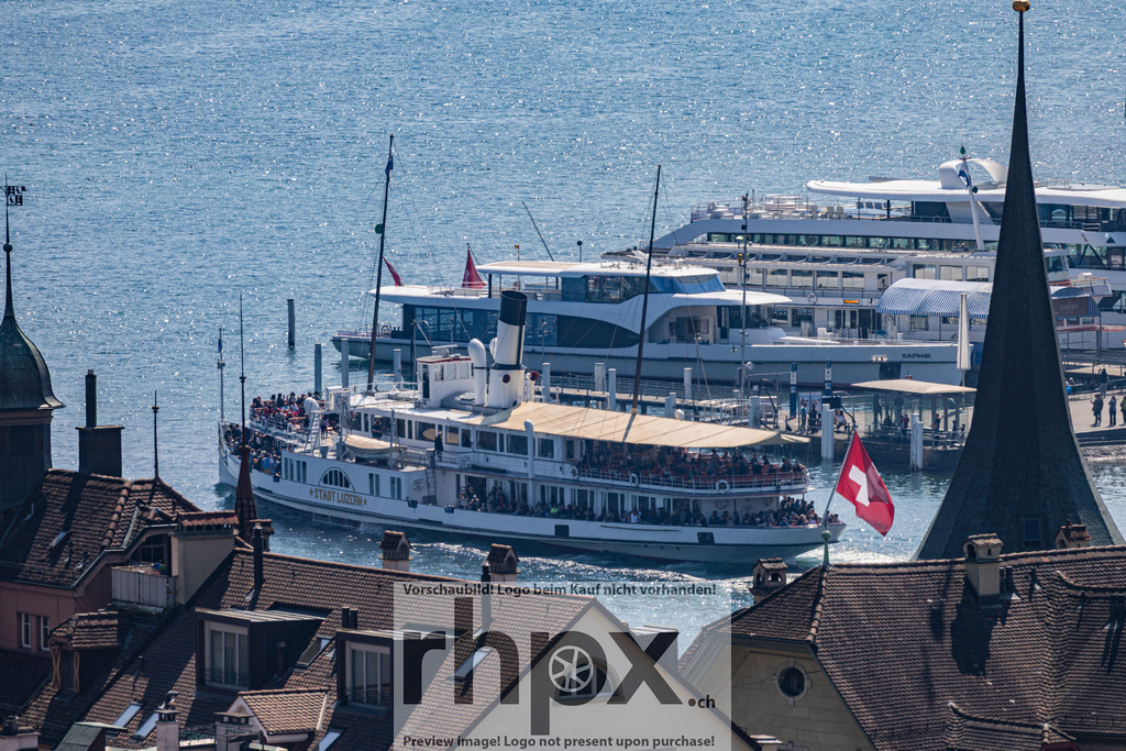 Luzerner Schifflände am Vierwaldstättersee | Dächer. See. Aufbruch.Ein faszinierender Blick über die warmen Ziegel der Luzerner Altstadt hinab zum pulsierenden Hafen. Das majestätische Dampfschiff "Stadt Luzern" dominiert die Szenerie und weckt vor dem glitzernden Panorama die Sehnsucht nach einer Fahrt auf dem blauen Wasser.Wähle unter "Produktauswahl" dein Wunschformat: Vom klassischen Wandbild über Puzzle &amp; Tassen bis zum digitalen Download (z.B. als Handy-Hintergrund). - Realisiert mit Pictrs.com
