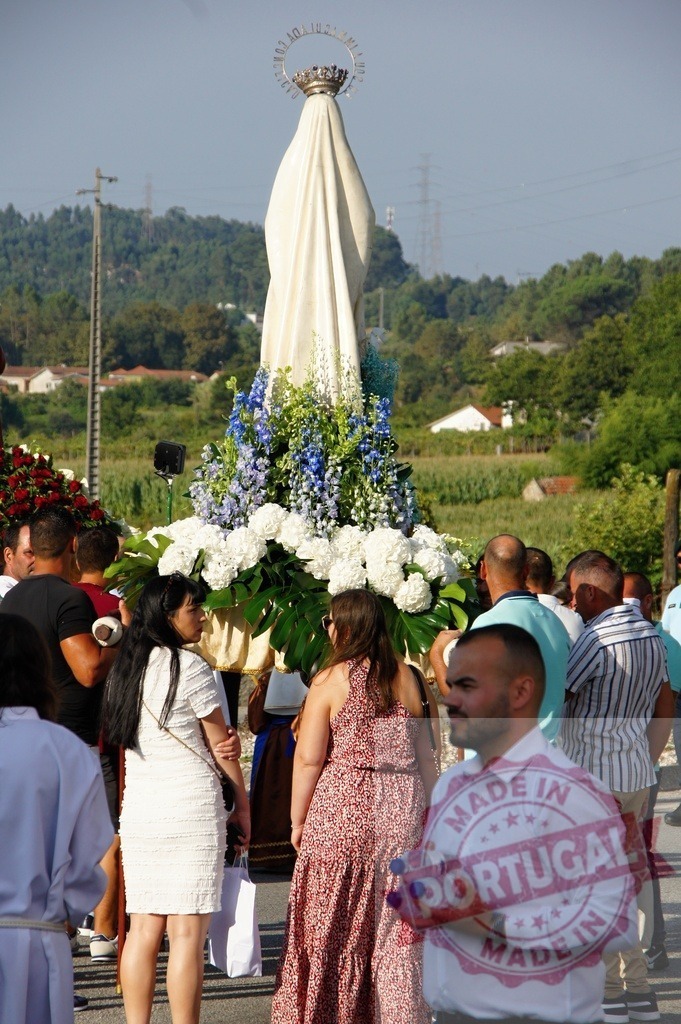 Faithful devotees carrying statue of Virgin Mary during religious procession | Procession 15.08.2025 - Assumption Day - Paco de Sousa, Portugal Devotees carrying statue of Virgin Mary decorated with flowers during a sunny religious procession - Realisiert mit Pictrs.com