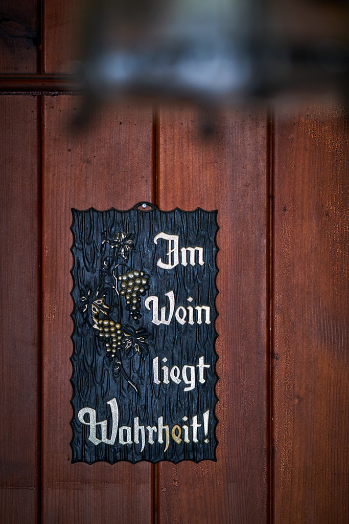 Innenraum einer leeren Gaststätte im Weinviertel | Austria - June 08, 2021: Innenraum einer leeren Gaststätte im Weinviertel, Weinspruch an der Wand hängend. - Realisiert mit Pictrs.com