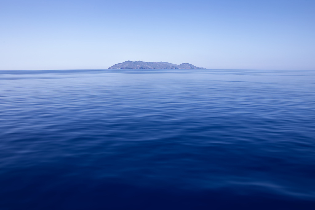 Inselblick, Mittelmeer | Insel im Mittelmeer, aufgenommen während einer Fährüberfahrt von Italien nach Korsika. Das Meer im satten Blau und mit seinen sanften Wellen strahlt Ruhe und Frieden aus. Unsere Empfehlung: Alu-Dibond oder Acrylglas - Realisiert mit Pictrs.com
