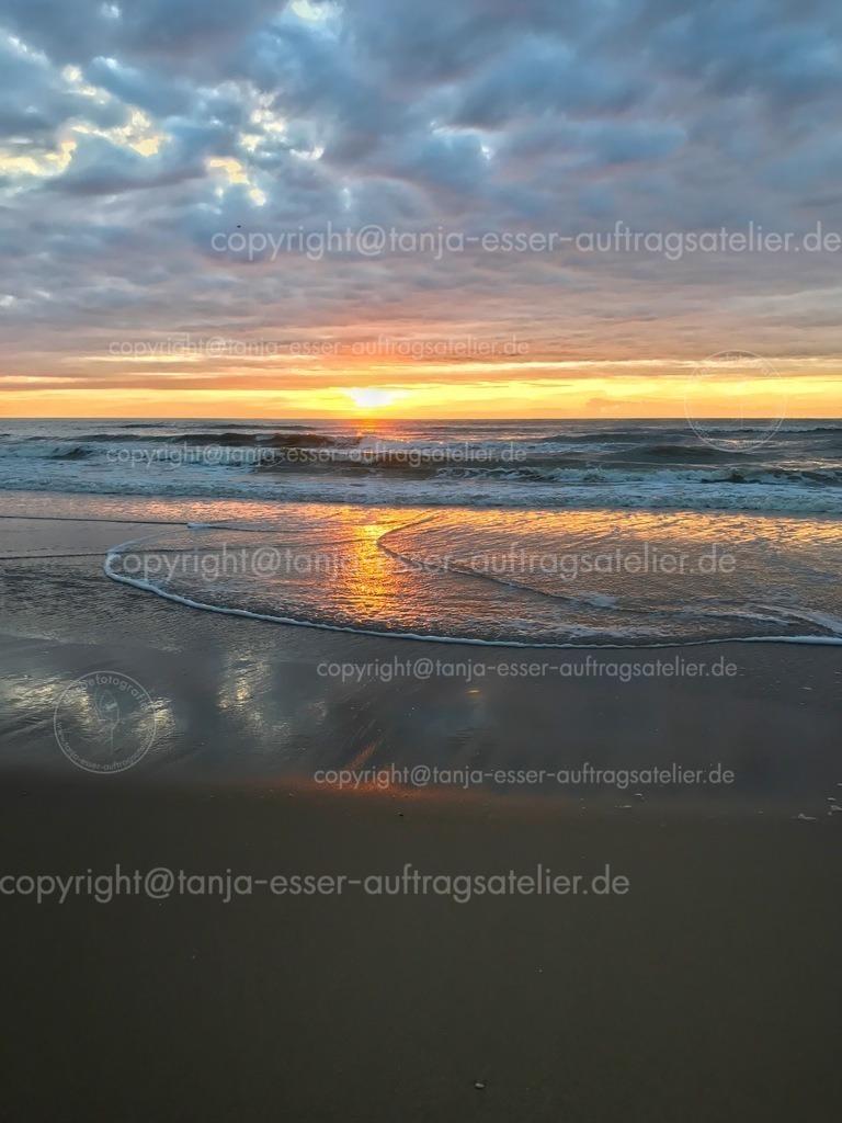 Sonnenuntergang und Wellen am Meer der Nordsee | Traumhafter Sonnenuntergang an der Nordsee. Der Sand ist dunkel und bietet Copy Space.