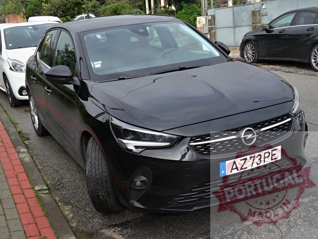 Black Opel Corsa car parked on a European street | Black Opel Corsa hatchback parked on a street with a Portugal license plate - Realisiert mit Pictrs.com