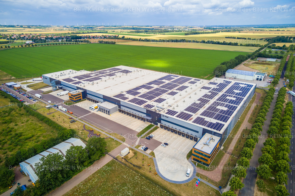 8_Barleben_Fiege-0025 | Blick aus der Drohne auf das Fiege-Logistikzentrum an der Otto-von-Guericke-Allee. Das Firmengelände, das in der vorherigen Aufnahme noch als Teil des großräumigen Gewerbestandortes zu sehen war, steht hier selbst im Mittelpunkt.Die Drohnenperspektive zeigt die Dimension des Logistikstandortes, die großen Hallenflächen, Verkehrswege und das weitläufige Firmengelände. So lässt sich ein Unternehmen nicht nur als einzelnes Gebäude, sondern als funktionierender Standort dokumentieren.Den Aufbau und die Entwicklung dieses Standortes habe ich fotografisch über einen längeren Zeitraum begleitet – sowohl vom Boden als auch aus der Drohne. Dadurch entstand eine umfassende Dokumentation der Baustelle und des Baufortschritts aus unterschiedlichen Perspektiven.Gerade die Kombination verschiedener Aufnahmetechniken ermöglicht bei solchen Projekten eine vielseitige Bildserie: Übersichten aus der Luft, detailreiche Drohnenaufnahmen und klassische Fotografien vom Boden ergänzen sich und dokumentieren die Entstehung eines Unternehmensstandortes umfassend. - Realisiert mit Pictrs.com
