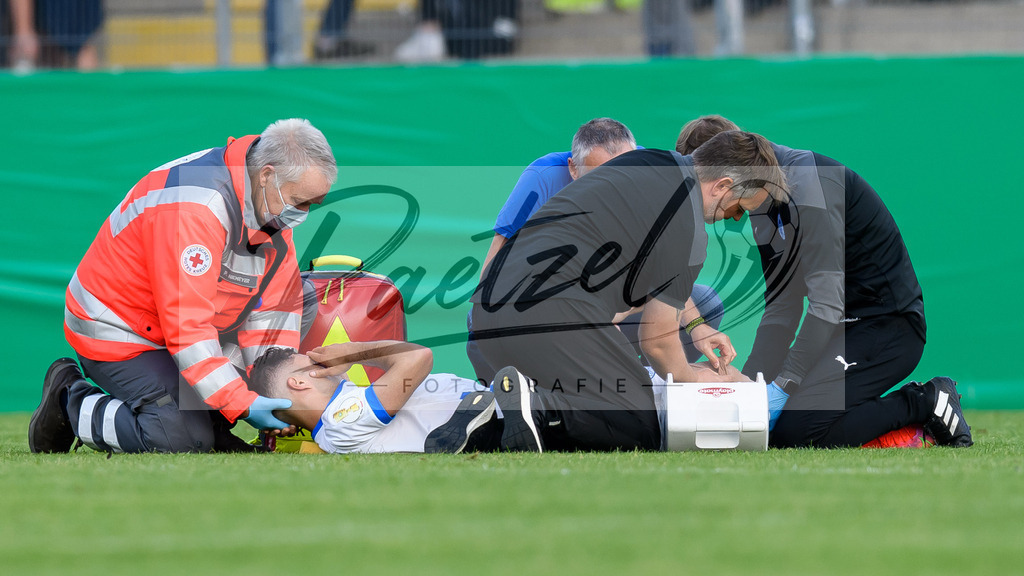 LOTKSC20210809_029 | Fussball, Herren: Cinar Sansar (Sportfreunde Lotte) verletzt am Boden und wird behandelt beim Spiel der 1. Runde im DFB-Pokal zwischen SF Lotte und Karlsruher SC im Stadion am Lotter Kreuz am 09.08.2021 in Lotte, Deutschland.DFB / DFL REGULATIONS PROHIBIT ANY USE OF PHOTOGRAPHS AS IMAGE SEQUENCES AND/OR QUASI-VIDEO. - Realisiert mit Pictrs.com