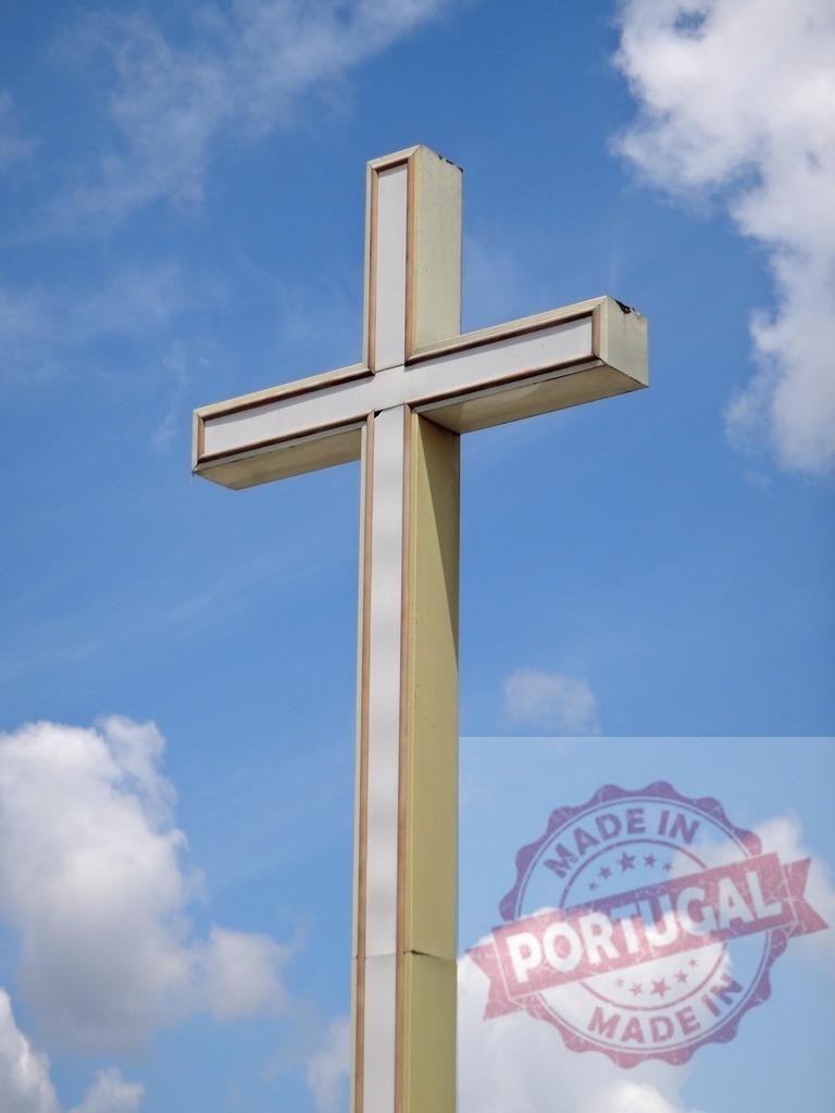 Christian cross reaching high to blue sky | Modern religious cross standing tall against a bright blue sky with white clouds - Realized with Pictrs.com