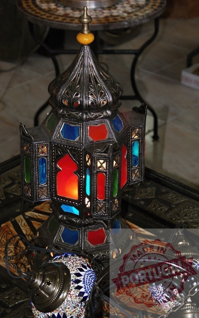 Moroccan lantern illuminating Middle Eastern traditional decor | Ornate Moroccan lantern with colorful glass panels bringing ambient light to a decorated interior - Realisiert mit Pictrs.com