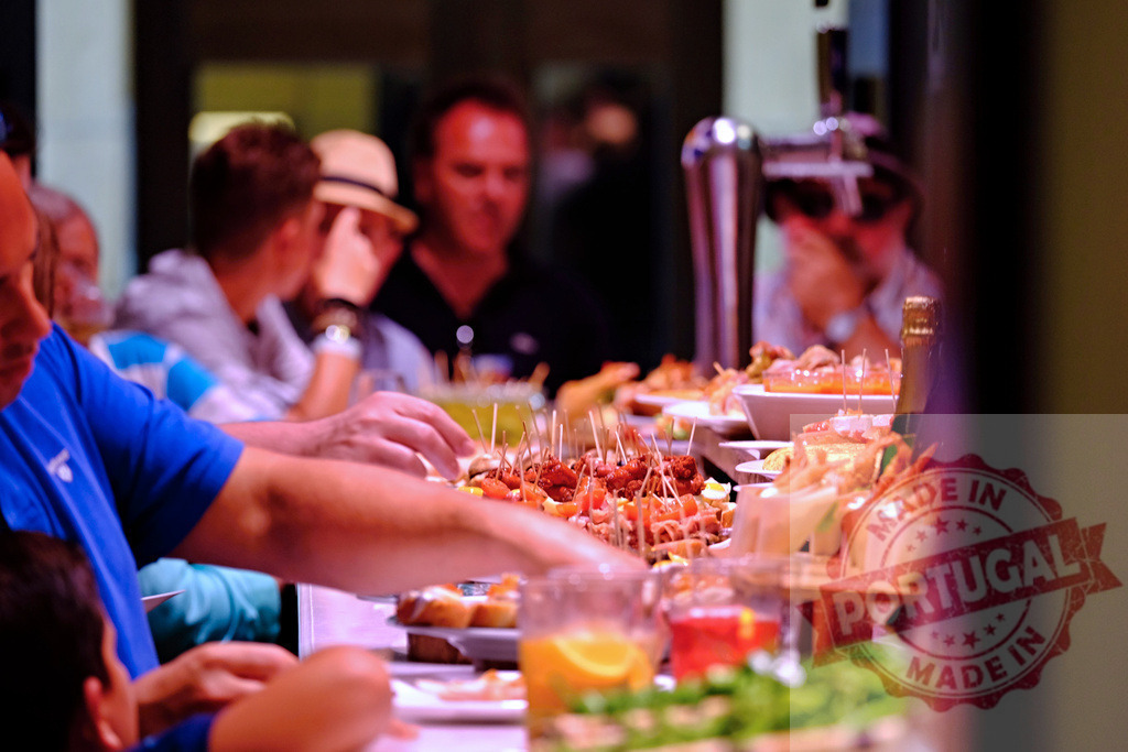 People enjoying tapas and pinchos at a bar | Customers selecting various Spanish tapas and pinchos from a self-service bar - Realisiert mit Pictrs.com