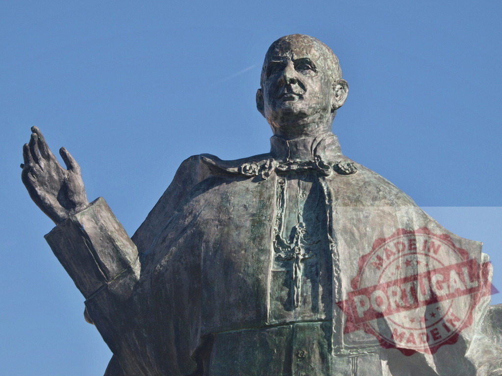 Bronze statue depicting Pope Paul VI blessing under blue sky | Bronze statue of Pope Paul VI with his right hand raised in a gesture of blessing - Realized with Pictrs.com