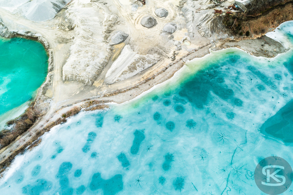 Zugefrorene Kiesgrube aus der Luft – Faszinierende Winterlandschaft als Drohnenaufnahme | Beeindruckende Luftaufnahme einer zugefrorenen Kiesgrube im Winter. Die Drohnenfotografie zeigt türkisblaues Eis und abstrakte Naturmuster aus der Vogelperspektive – einzigartige Winterlandschaft von oben. - Realisiert mit Pictrs.com