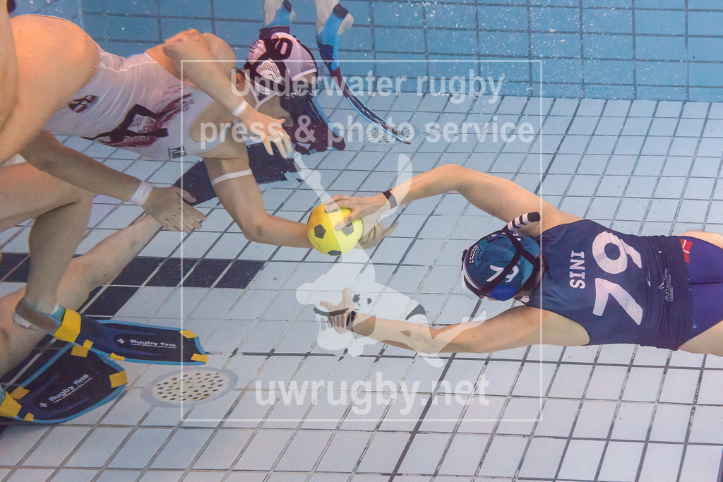 24. - 26.11.2023: Unterwasser-Rugby Champions Cup 2023  | Damen-Spiel um Platz 5:  Amager Uv-Rugby (Dänemark) in blau gegen UWRC Wien / Österreich in weiß. Stephanie Popp (weiß #10) stopped Sini Korppi-Tommola (blau #79) beim Angriff auf das Tor der Wiener Damen. - Realisiert mit Pictrs.com