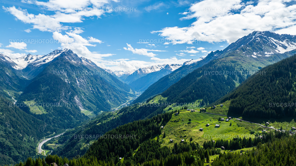 Alpine Valley _ The Heart of Switzerland | Ein atemberaubender Panoramablick tief in die Schweizer Alpen, wo üppige grüne Wälder, verstreute Berghütten und schneebedeckte Gipfel eine perfekte Harmonie aus Farben und Tiefe bilden. Das dramatische V-förmige Tal lenkt den Blick auf natürliche Weise durch die gesamte Szenerie und vermittelt ein Gefühl von Freiheit, Weite und der Reinheit der Berge.Dieser FineArt-Druck bringt Eleganz, Ruhe und Inspiration in jeden Raum – ideal für Naturliebhaber und Kenner alpiner Landschaften. - Realisiert mit Pictrs.com