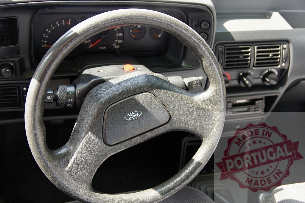 Ford vintage car interior showing steering wheel and dashboard | Ford car interior featuring a steering wheel, dashboard, and instrument panel - Realized with Pictrs.com
