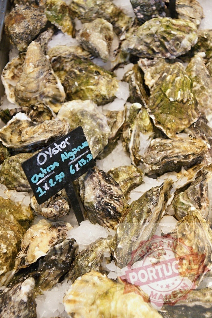 Fresh Ostras Algarve oysters on ice with price tag | Fresh Ostras Algarve oysters on ice with a price tag showing different purchase options - Realisiert mit Pictrs.com