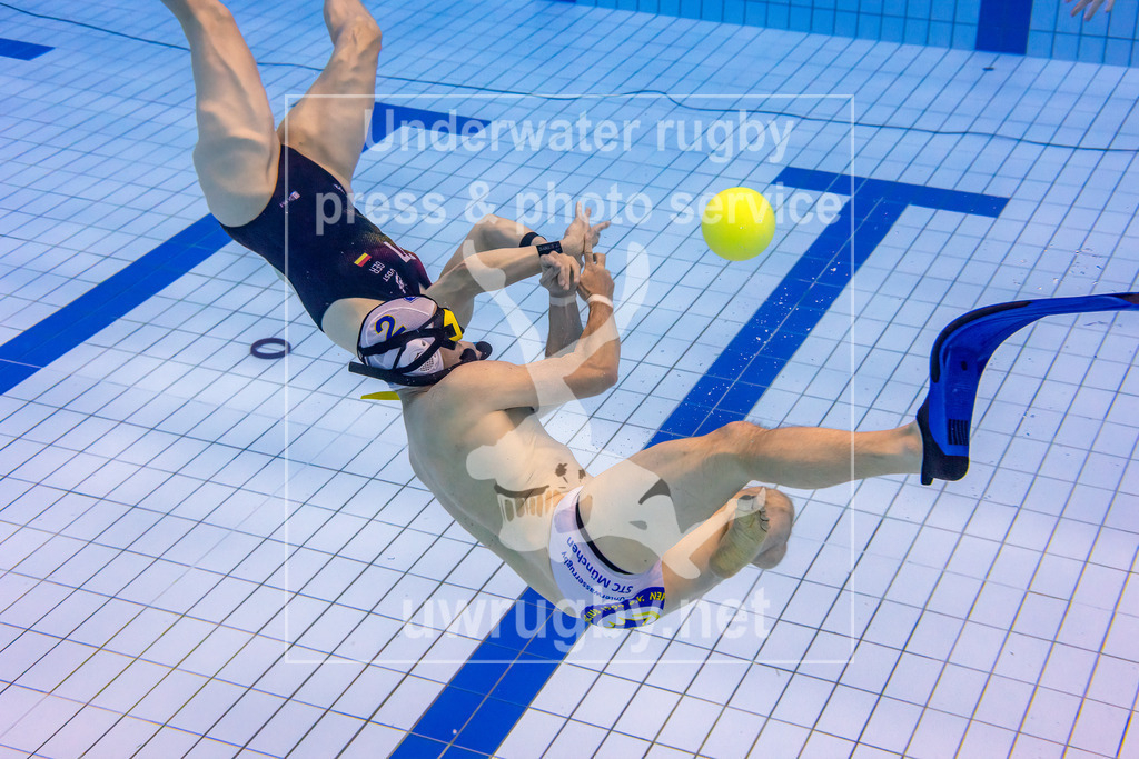Unterwasser-Rugby 5. Spieltag 1. Bundesliga Süd (Saison 2023/24) | Spiel TC Stuttgart in blau gegen STC München in weiß. Ball schwebt in der Spielfeldmitte, der Münchner Stefan Klett hat eine Flosse verloren und kämpft mit seiner verbliebenen Flosse um den Ball. - Realisiert mit Pictrs.com