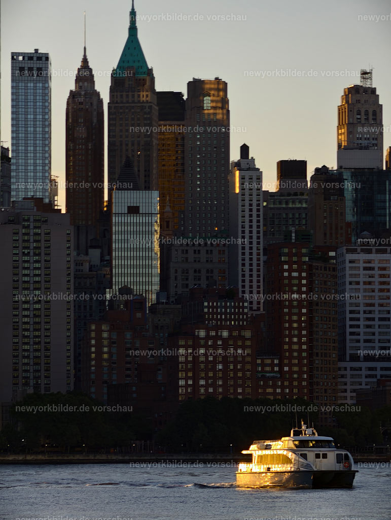 Morgenzauber am Hudson River – Manhattan Skyline | Ein Morgen am Hudson River, der die Stadt in goldenes Licht taucht. Die Manhattan Skyline erhebt sich im Hintergrund, während die aufgehende Sonne durch die klare Luft strahlt und die Fassaden der Wolkenkratzer zum Glühen bringt. Im Vordergrund gleitet eine Fähre über das ruhige Wasser, ihre Konturen von warmem Licht umspielt. Die Szene wirkt wie ein Gemälde – kraftvoll und zugleich friedlich. Der Kontrast zwischen der urbanen Kulisse und der sanften Morgenruhe macht diesen Moment einzigartig. Es ist die perfekte Verbindung von Bewegung und Stille, von Stadtleben und Natur, eingefangen in einem Augenblick voller Magie