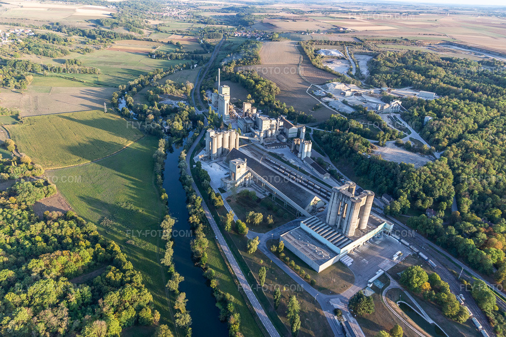 Aerial view: Site and spoil heaps of the cement open-pit mine and building materials plant of Ciment Vicat in Xeuilley in the state Meurthe et Moselle, France. – Photo: IMG_117888.jpg taken on 09/14/2019 by Werner Riehm/FLY-FOTO.com – Resolution of the original: 5472 x 3648 px