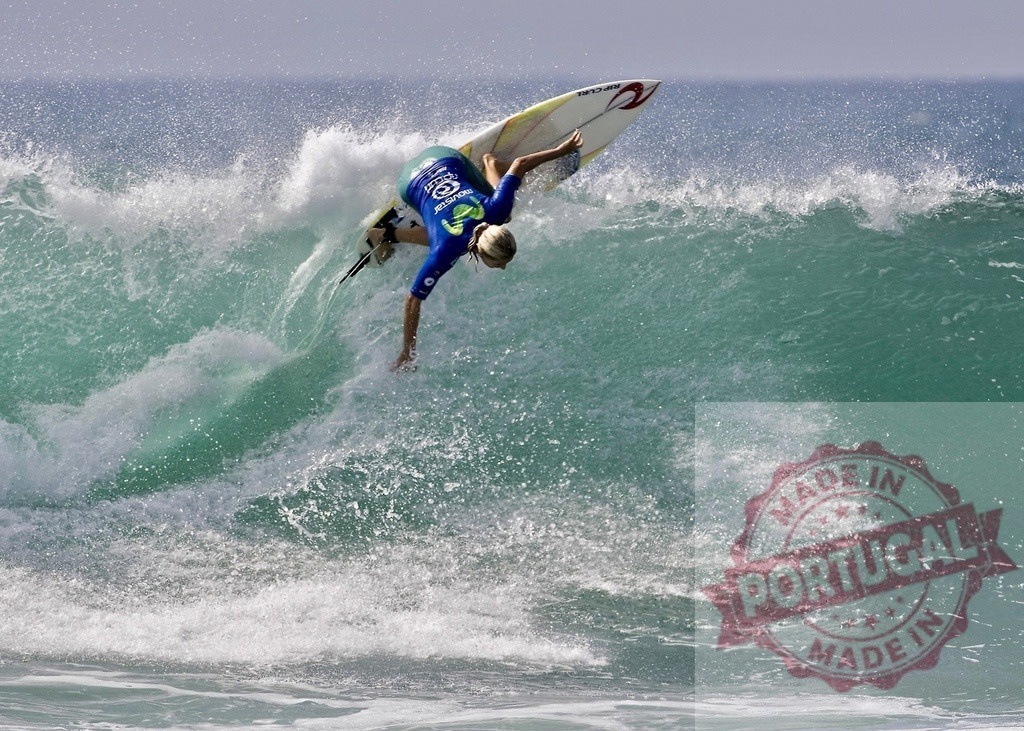 Professional surfer performing an aerial maneuver during a competition | Surfer twisting his body while holding onto his board, performing an aerial maneuver during a surfing competition - Realisiert mit Pictrs.com