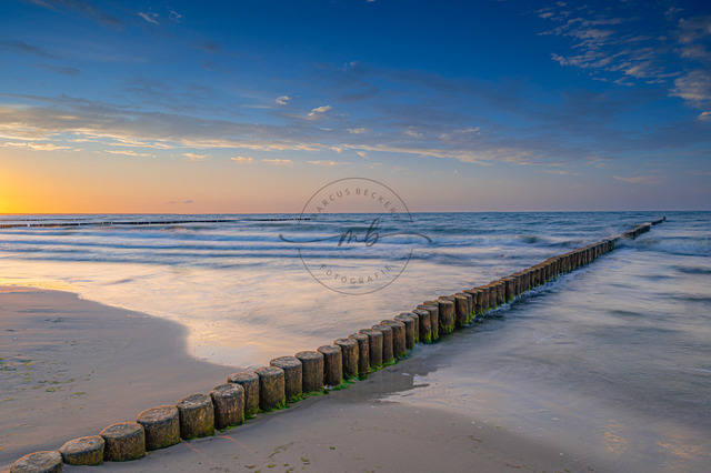 2026-08-06_20-38-41_570 (2026-08-06T20_14_24.727) | Buhnen verlaufen parallel zum Strand in die Ostsee unter einem ruhigen Himmel bei Sonnenuntergang, Zempin, Usedom, Mecklenburg-Vorpommern, Deutschland - Realisiert mit Pictrs.com