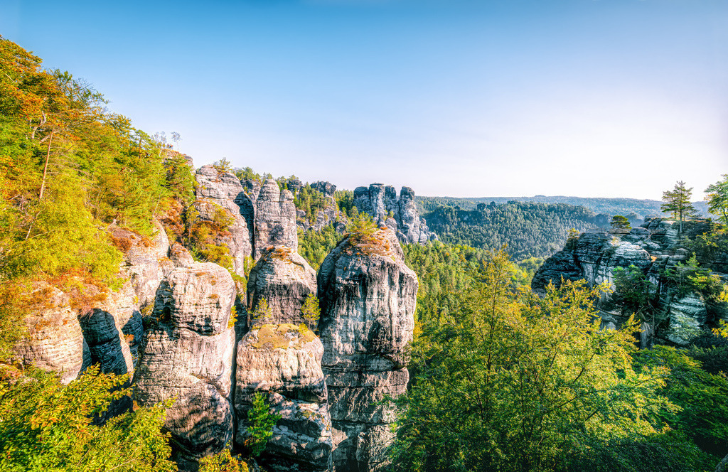 Panoramablick auf berühmte Felsen Sächsischer Schweiz | Dies ist ein Panoramablick auf die berühmten Felsformationen der Bastei im Nationalpark Sächsische Schweiz.Die Felsen befinden sich in der Nähe von Dresden und Rathen im Elbsandsteingebirge.Das Gebiet ist bekannt für seine Wanderwege und Klettermöglichkeiten.In der Nähe liegt die weltberühmte Basteibrücke, die ganzjährig zugänglich ist - Realisiert mit Pictrs.com