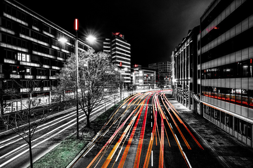 Eine Aufnahme der B27 - Theodor-Heuss-Straße in Stuttgart bei Nacht,mit Lichtspuren in SW und Farbe | Die Aufnahme zeigt die Bundesstraße B27 in der Stuttgarter Innenstadt direkt am Hauptbahnhof bei Nacht mit farbigen Lichtspuren.Ort: Stuttgart (B27 nahe Hauptbahnhof)Stil: Schwarz-Weiß-Fotografie mit selektiven roten und orangefarbenen Lichtspuren (Light Trails) - Realisiert mit Pictrs.com
