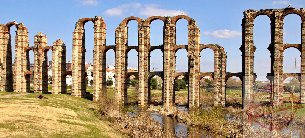 Acueducto de los Milagros Roman aqueduct ruins in Merida, Spain. Extremdura - Spain | Acueducto de los Milagros featuring ancient Roman arches stretching over a stream and grass - Realisiert mit Pictrs.com
