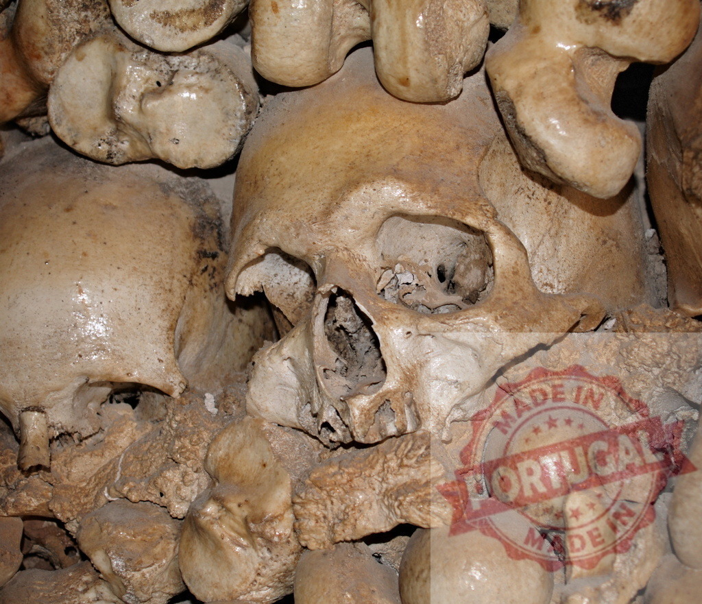 Human skulls and bones arranged in an ossuary wall | Human skulls and bones forming a wall inside an ancient ossuary - Realized with Pictrs.com